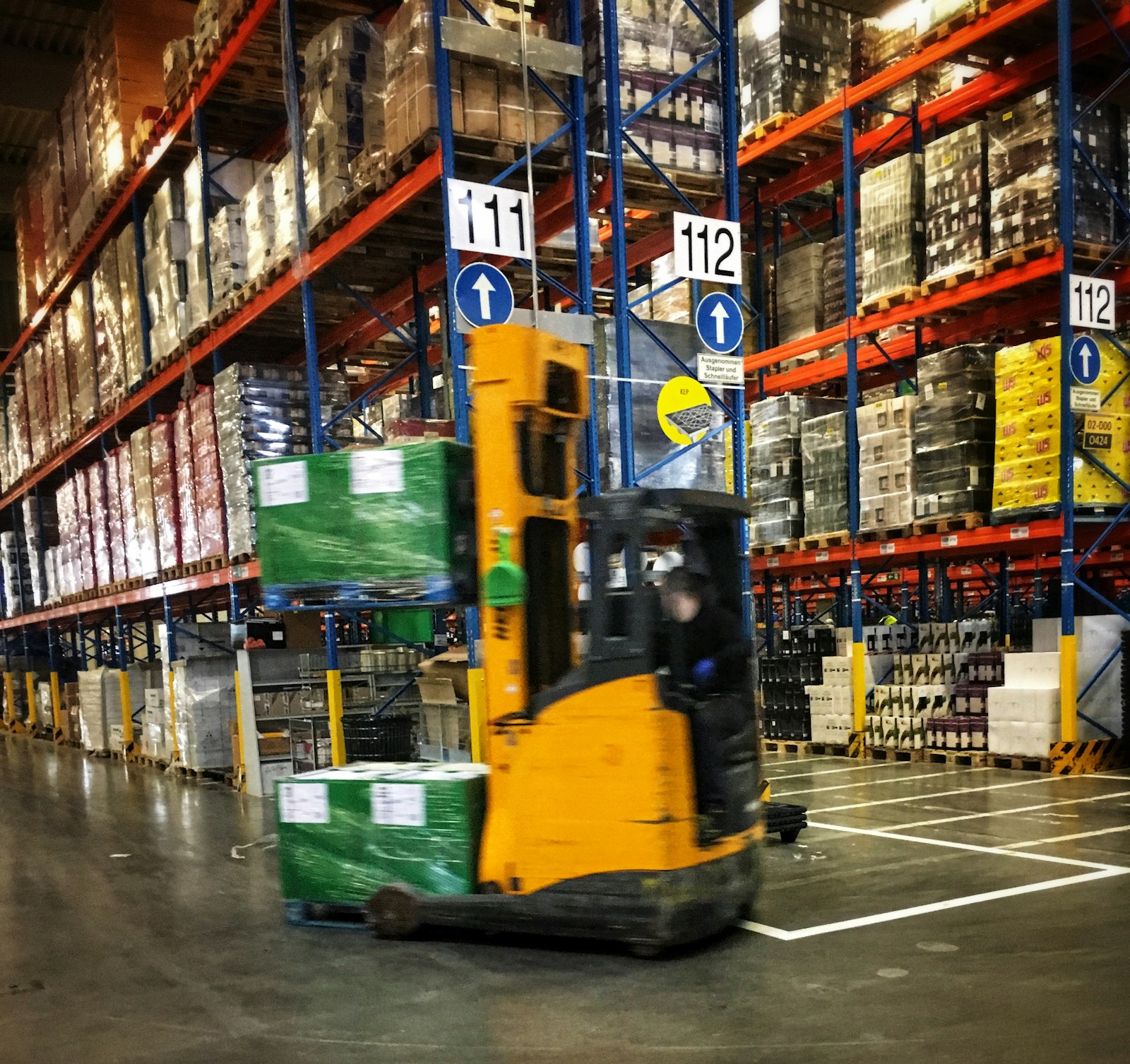 Forklift operando en bodega con racks de inventario